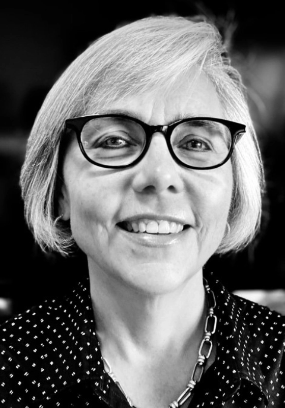 A black and white photo of a woman with glasses.